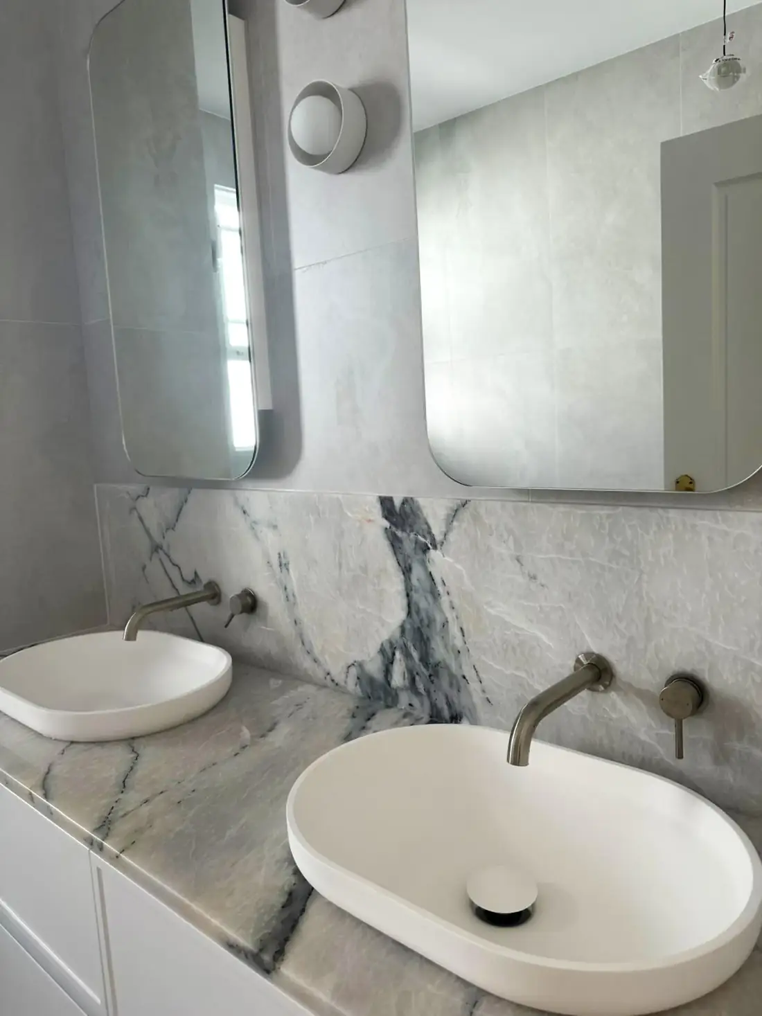 Marble double vanity with brushed nickel tapware and twin mirrors